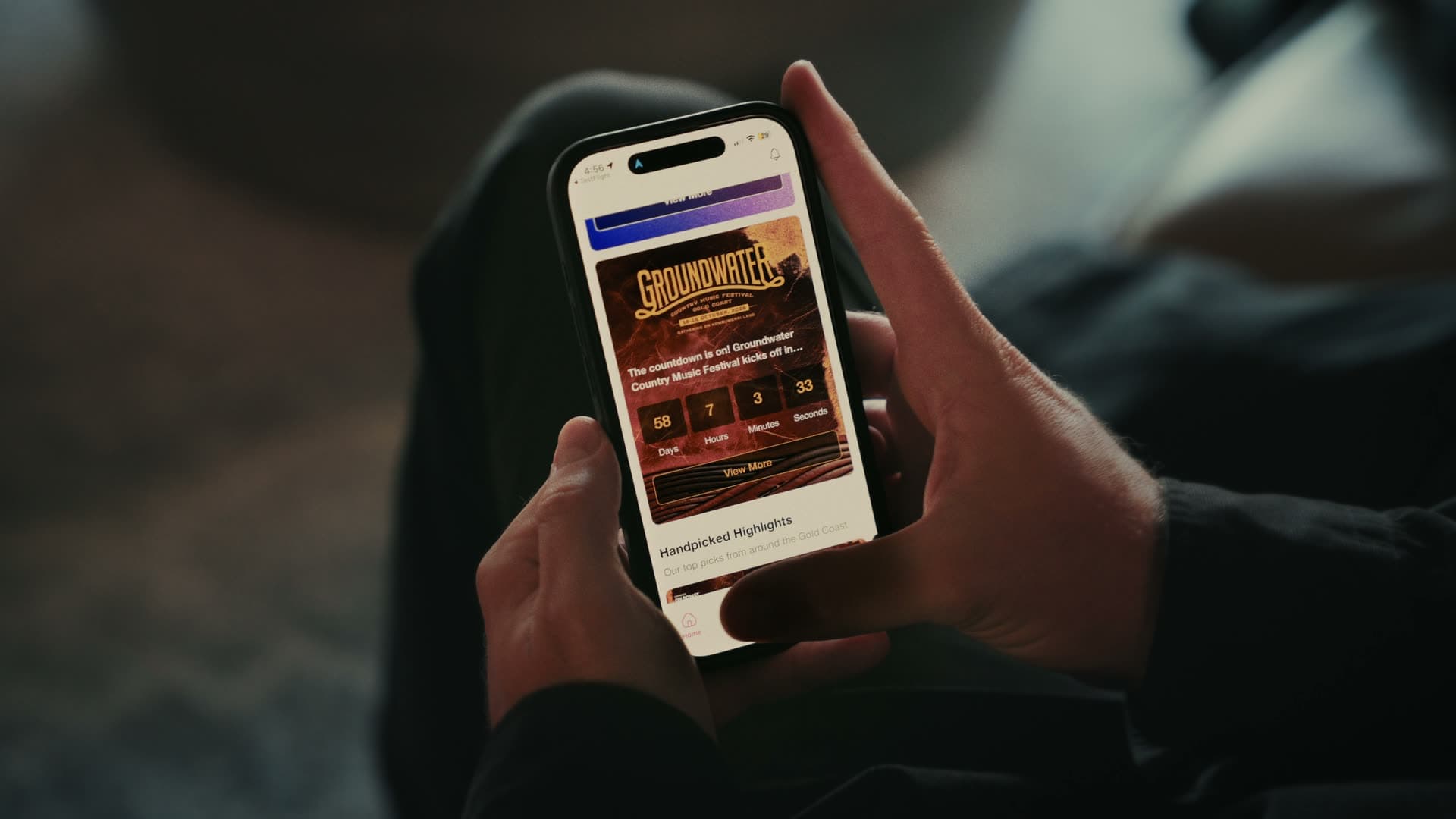 Hands using the Groundwater Country Music Festival app on iPhone